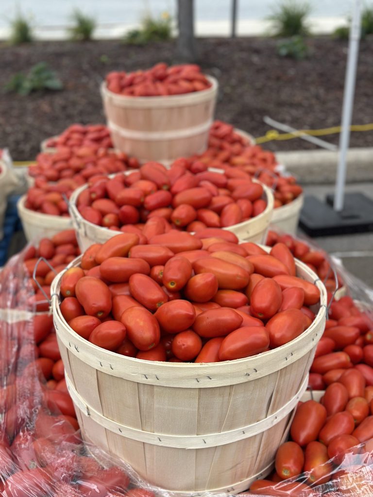 Wooden bushels filled with bright red roma tomatos