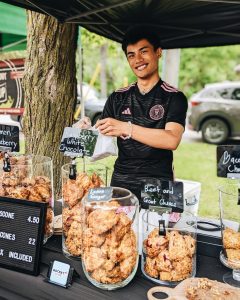 Young man in black shirt serving scones